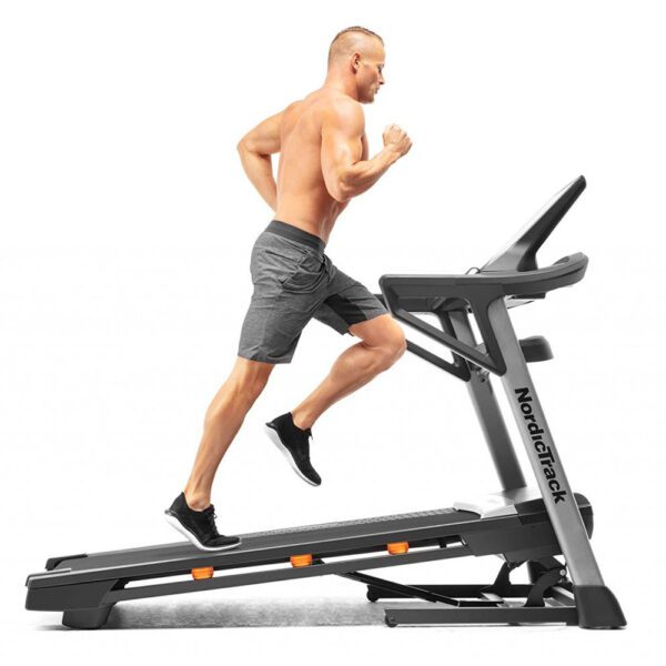 NordicTrack T 7.5 S bėgimo takelis su bėgančiu žmogumi, demonstruojantis patogias treniruotes su reguliuojamu greičiu ir pasvirimo kampu namuose.
